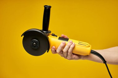 Sarı arkaplanda modern, kompakt sarı açı öğütücü izole