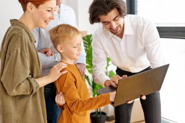 Emlakçı, yeni eve ya da daireye taşınmadan önce oğlu olan genç aileye kirayı ya da satın almayı açıklar.