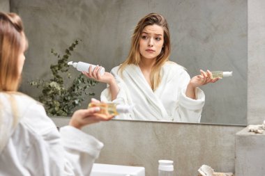 Güzel sarışın kadın seçer, kozmetik ürünlerini karşılaştırır, hangisi daha iyi olur?