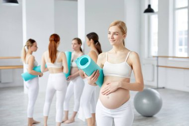 Yogadan önce stüdyosunda spor paspası olan güzel bir anne.