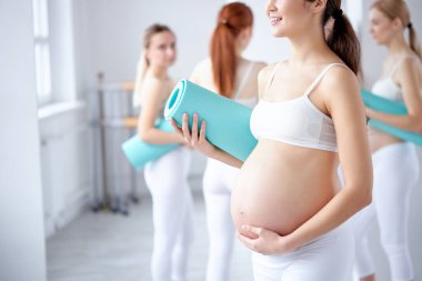 Büyük hamile göbeği olan esmer bir kadın.