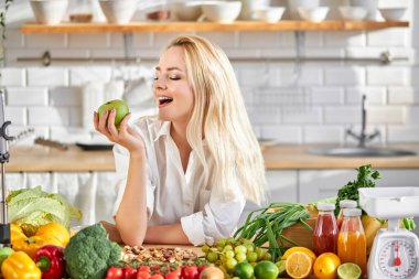 Yeşil elma yiyen, sağlıklı beslenmenin tadını çıkaran çekici bayan.