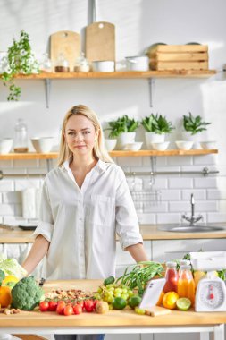 Dişi, mutfakta taze sebzelerden yemek hazırlamakla meşgul.