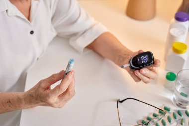 Bir Kadının Eli Glukometreyle Yüksek Kan Şekeri Testi Yapıyor