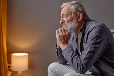 Üzücü bir son sınıf öğrencisi kaygıyla aşağıya bakıyor, üzücü bir şey düşünüyor.