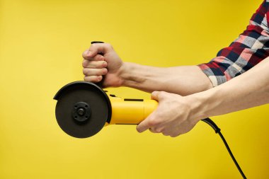 Erkek, modern çalışma aletini açar, el bilgisayarı, sarı elektrikli yuvarlak tahta testeresi, Bulgar...