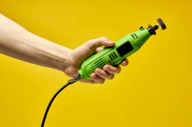 Kopyalama alanı, yakın çekim yeşil boya öğütücüsü kırpılmış erkek ellerinde