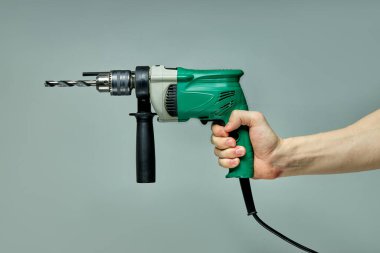 Kesilmiş erkek ellerinde yakın plan yeşil elektrikli çekiç.