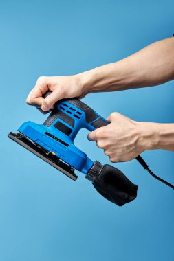 Mavi arkaplanda titreşimli elektrikli zımpara makinesi