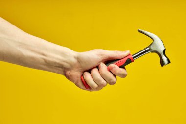 Kırpılmış erkek ellerinde plastik saplı yakın çekiç.