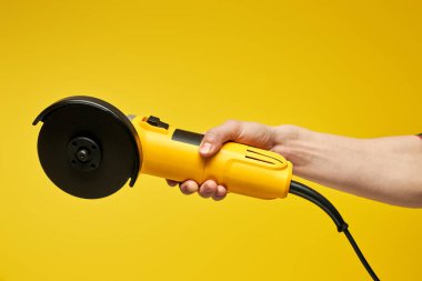 Modern çalışma aleti, el bilgisayarı, sarı elektrikli yuvarlak tahta testeresi, Bulgarca, açı öğütücü sarı üzerine izole edilmiş.