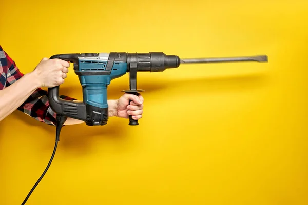 Cropped male holding green puncher for repair isolated on yellow — Stock Photo, Image