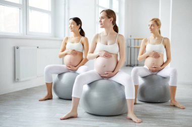 Rahatlamış hamile kadınlar aktif ve sağlıklı bir yaşam sürüyorlar. Yoga fitness sporuna gidiyorlar.