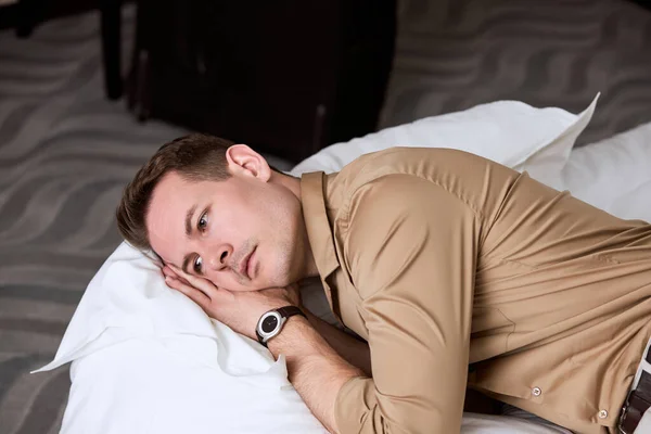 Esausto uomo sconvolto sdraiato sul letto con depressione, pensando a qualcosa — Foto Stock