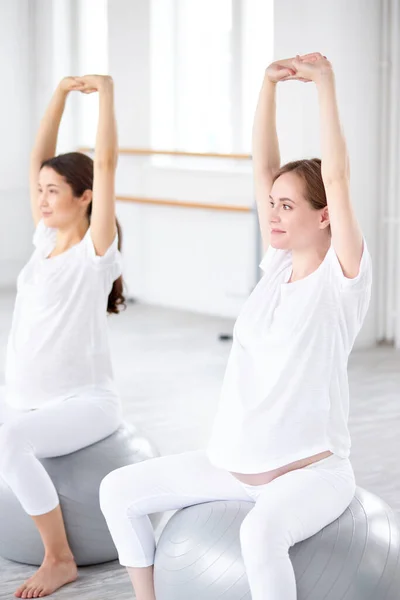 Prachtige zwangere vrouwen doen oefeningen voor te bereiden op de bevalling, training spieren — Stockfoto