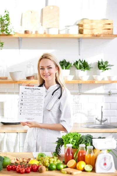 손에 쥐고 있는 고객을 위한 건강 한 탈지제 다이어트 목록을 들고 있는 의사 — 스톡 사진