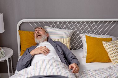 Hasta kıdemli adam yatakta yatarken hapşıracak.