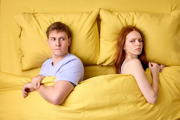 Entfremdetes Millennial-junges Paar im Bett, achten Sie aufeinander, dass sie nicht miteinander reden. Top-Down-Schuss. — Stockfoto