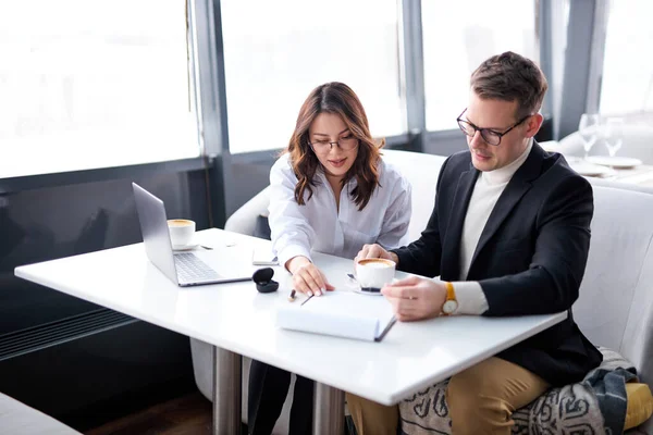 Negocios caucásicos personas hablando en la reunión en el restaurante, se sientan con el ordenador portátil en la mesa, co-working — Foto de Stock