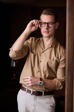 Zarif kahverengi gömlekli Kafkasyalı vahşi adam kameraya bakıyor.