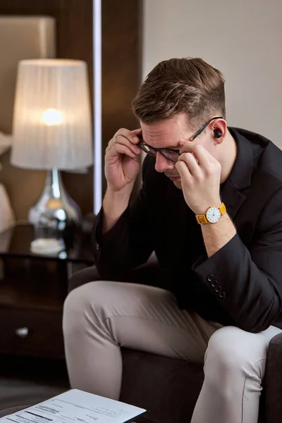 Thoughtful doubtful businessman in tension thinking make difficult decision at work, stressed man sit alone in room