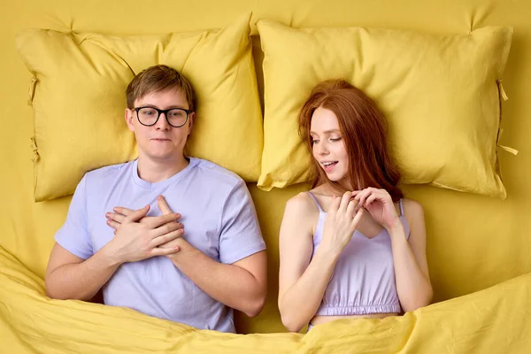 İlk seks deneyiminden sonra yorganın altında yatan mutlu çift, yatakta kadınların becerilerine şaşırır. — Stok fotoğraf
