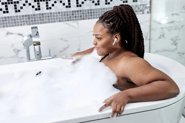 Черные женщины, расслабляющиеся в спа-ванне отеля или домашней ванной комнате для полной релаксации — стоковое фото
