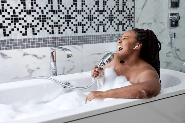 Портрет красивый молодой афро-американской женщины расслабиться и досуг в ванной украшения в ванной комнате интерьера — стоковое фото