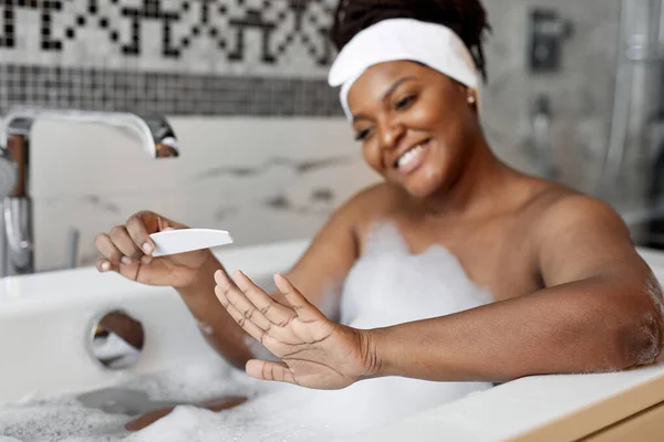 Retrato de mujer africana sonriente atractiva mirando hermosas uñas después de manicura, manos de cerca —  Fotos de Stock