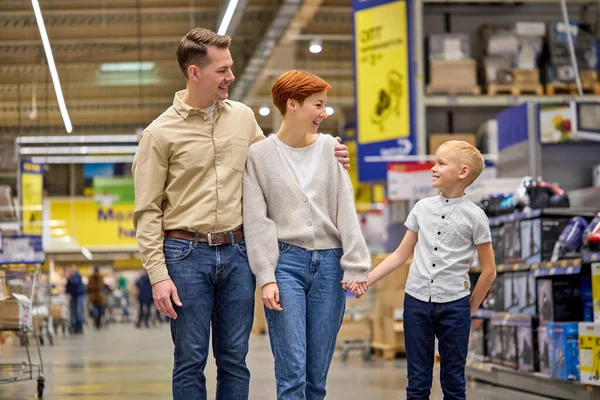 Młody Syn Dziecko Chłopiec Walking z rodzicami w supermarkecie, podczas gdy trzymając się za ręce szuka nowych rzeczy dla domu — Zdjęcie stockowe