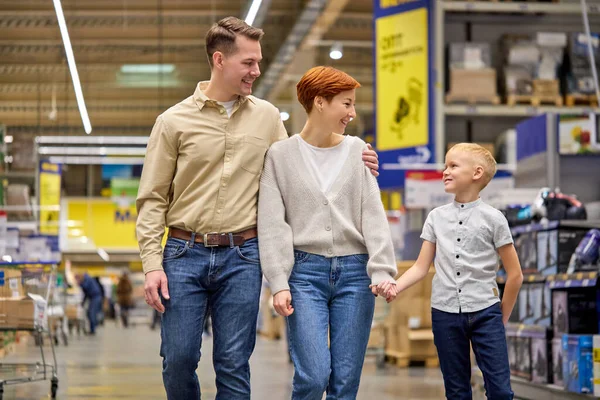 Amistosa familia americana europea con hijo preadolescente caminando en la tienda y hablando — Foto de Stock