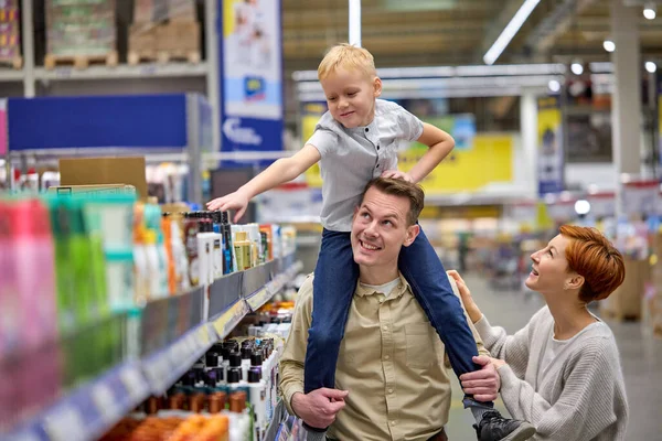 Joven caucásico hombre llevando hijo en cuello, familia en supermercado — Foto de Stock