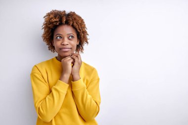 Hayalperest Afro dişi ellerini birarada tutuyor, düşünüyor, boş alana bakıyor derin düşünüyor.