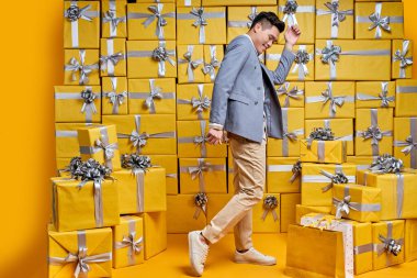 Asyalı Çinli adam dans ediyor doğum günü hediyeleri alıyor, gururlu ve zaferi kutluyor ve başarıyı kutluyor heyecanlı, coşkulu