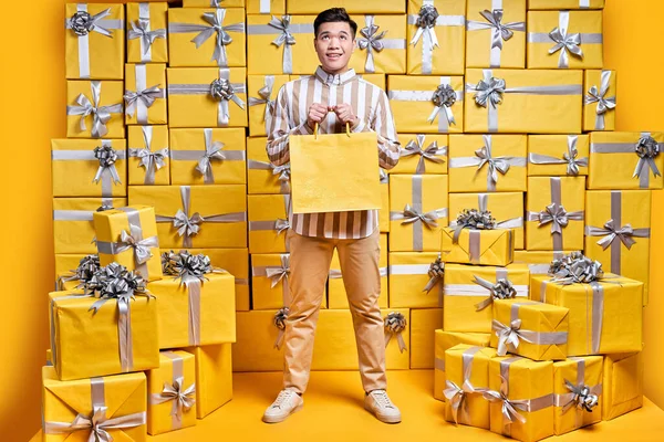 Joven caballero chino sosteniendo algunas bolsas de la compra, va a celebrar cumpleaños, felicitar — Foto de Stock
