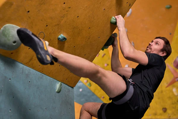 男子攀岩者攀爬人造岩石，男子训练力量和耐力 — 图库照片