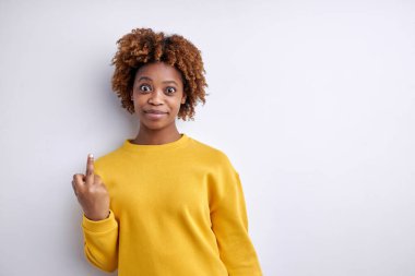 Portrait of attractive afro american woman making fuck you sign. Naughty concept