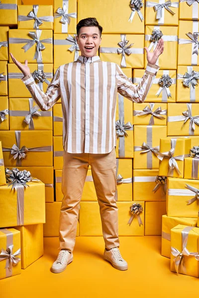 Chico chino emocional en camisa casual es sorprendido por conseguir muchos regalos para el cumpleaños — Foto de Stock