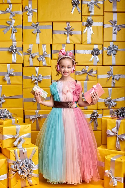 Lindo positivo feliz niña pequeña usando vestido de fiesta celebración de caja de regalo y divertirse — Foto de Stock