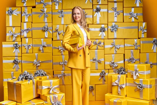 Elegante hermosa mujer rubia con traje amarillo sosteniendo bonito bolso — Foto de Stock