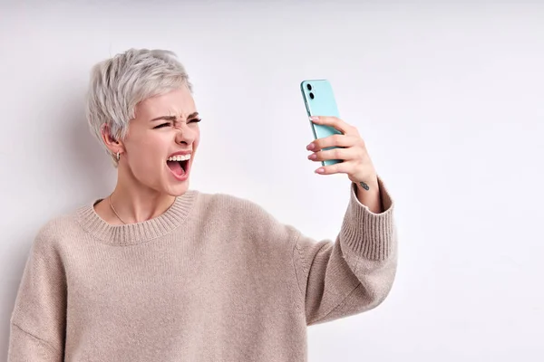 Portret van een kortharige boze vrouw die ruzie maakt met iemand terwijl ze telefoneert — Stockfoto