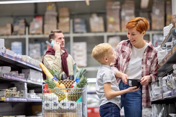 Kaukaski chłopiec pomaga matka do wyboru podczas kupowania potraw — Zdjęcie stockowe