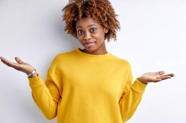 Cahil, genç, Afro-Amerikan bir kadın tereddütle omuz silkiyor, şüpheli bir durumla karşı karşıya.