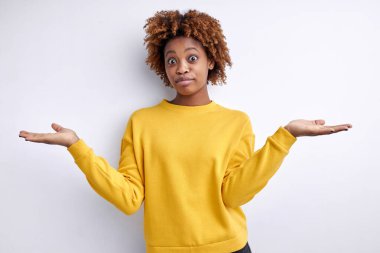 Cahil, genç, Afro-Amerikan bir kadın tereddütle omuz silkiyor, şüpheli bir durumla karşı karşıya.