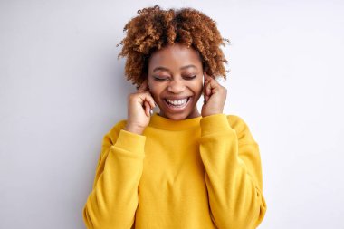 İyimser Afrikalı Kadın kulaklıkla müzik dinlemekten ve gülümsemekten zevk alıyor.