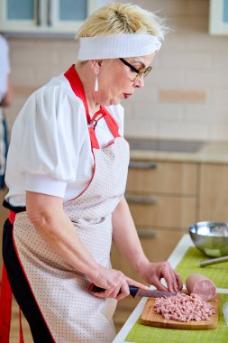 Mutlu hafta sonları. Olgun bir kadın mutfakta aile için yemek hazırlıyor.