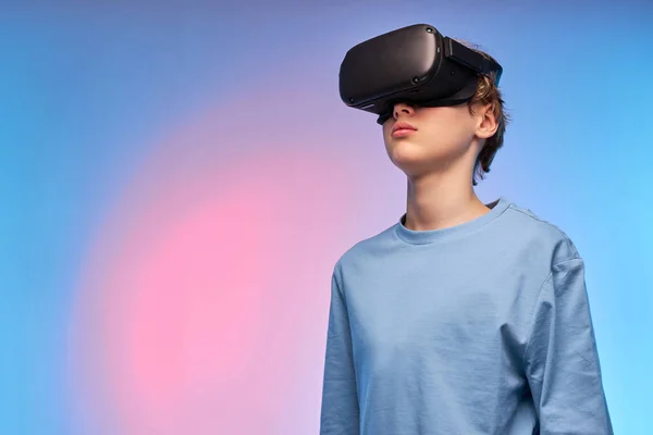 Sebevědomý dospívající chlapec ve VR brýle dívá pryč vážně, Představte si něco fantastického — Stock fotografie