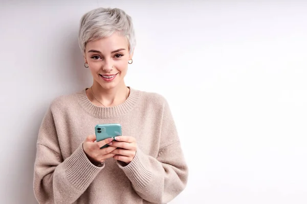 Mooi vrouw met blond kort haar chatten met iemand op mobiele telefoon, lachen schattig — Stockfoto