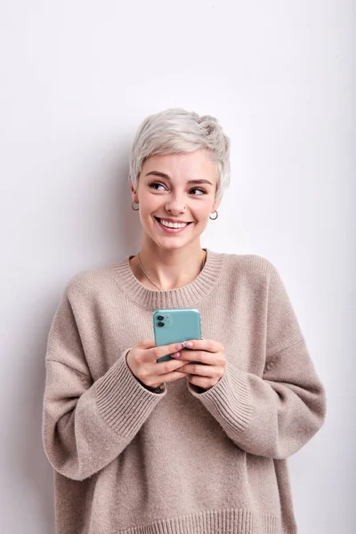 Schattig vrouw met blond kort haar chatten met iemand op mobiele telefoon, lachen schattig — Stockfoto