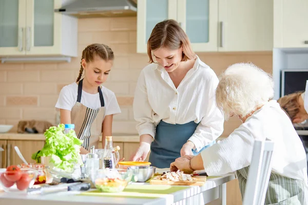 Ευτυχισμένες ενήλικες κυρίες διδασκαλία κοριτσάκι πώς να μαγειρεύουν, κοριτσάκι μάθηση, αντιγραφή χώρου — Φωτογραφία Αρχείου